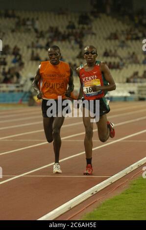 Athen, Griechenland 24SEP04: Kenias Henry Wanyoike (1796) in Aktion mit seinem Führer im Finale der 5000 Meter T11 für sehbehinderte Läufer bei den Paralympics. Der Kenianer gewann in 15:11,07 Minuten für eine Weltrekordzeit. ©Bob Daemmrich Stockfoto