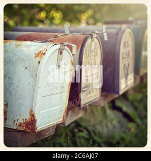 Verrostete US-Briefkästen in der Nachmittagssonne. Instagram-Style-Verarbeitung. Gefiltert, um wie ein veraltertes Sofortfoto zu aussehen.