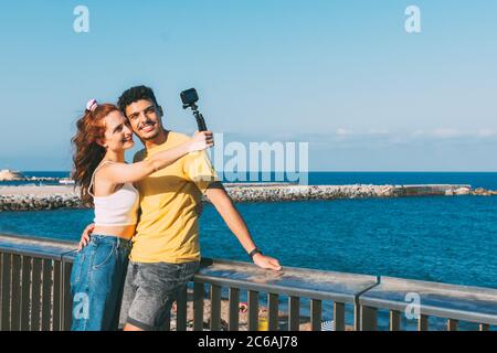 Im Sommer macht ein junges Paar ein Selfie am Strand Stockfoto