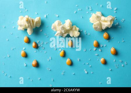 Zusammensetzung mit Popcorn, Salz und Samen auf blauem Hintergrund Stockfoto