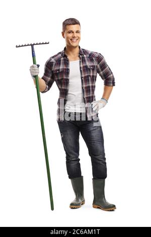 In voller Länge Porträt eines fröhlichen jungen Landwirt hält einen Rechen isoliert auf weißem Hintergrund Stockfoto