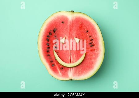 Wassermelone mit Smiley-Gesicht auf Minze-Hintergrund, Draufsicht Stockfoto