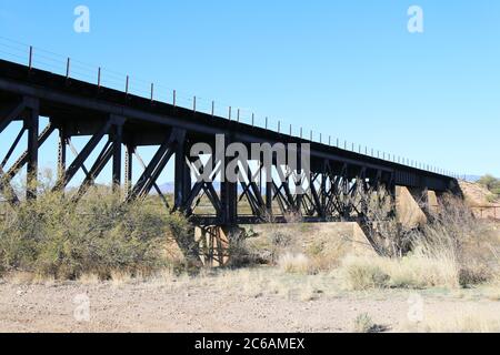 Eine hohe Eisenbahnbrücke über eine Wüstenschlucht mit blauem Himmel Stockfoto