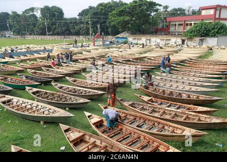 Ghior, Manikgan, Bangladesch. Juli 2020. Handgefertigte Holzboote werden am 08. Juli 2020 auf einem Bootsmarkt in Ghior, Manikgan, Bangladesch, zum Verkauf angeboten. Die Nachfrage nach verschiedenen Arten von kleinen Booten ist hier mit dem Anstieg des Wasserpegels in verschiedenen Flüssen und den anschließenden Überschwemmungen gestiegen. Die Nachfrage nach Dingi und Khosa Nauka (Kleinboot) hat sich für die regelmäßige Bewegung von Menschen in flutgefährdeten Gebieten hier erhöht. Quelle: Suvra Kanti das/ZUMA Wire/Alamy Live News Stockfoto