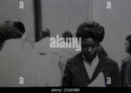 Feine 70er Jahre Vintage schwarz-weiß Lifestyle-Fotografie einer afroamerikanischen Frau, die in der Menge zu Fuß. Stockfoto