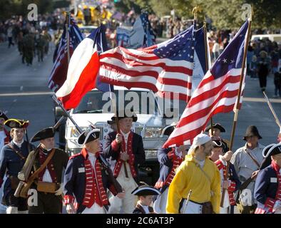 Austin, Texas, USA, November 11 2004: Männer in Kostümen des Revolutionskriegs tragen amerikanische Flaggen bei einer Parade auf der Congress Avenue, um den Veteran's Day zu feiern. ©Bob Daemmrich Stockfoto