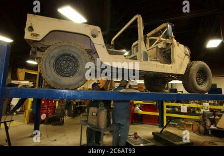 New Boston, Texas, USA, November 22 2004: Arbeiter des Red River Army Depot beeilen sich, um militärische Humvees zu reparieren, zu erneuern und zu rüsten, die für den Krieg im Irak bestimmt sind. Rund um die Uhr arbeiten Mechaniker auf der 33.000 Hektar großen Militärbasis im Nordosten von Texas. ©Bob Daemmrich Stockfoto