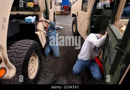 New Boston, Texas, USA, November 22 2004: Arbeiter des Red River Army Depot beeilen sich, um militärische Humvees zu reparieren, zu erneuern und zu rüsten, die für den Krieg im Irak bestimmt sind. Rund um die Uhr arbeiten Mechaniker auf der 33.000 Hektar großen Militärbasis im Nordosten von Texas. ©Bob Daemmrich Stockfoto