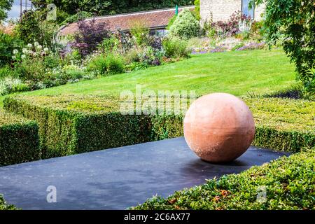 Ein Stück moderne Gartenkunst in einem englischen Landgarten. Stockfoto