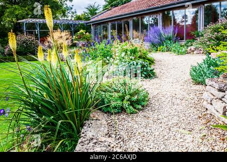 Terrassenförmig angelegte krautige Grenzen in einem abfallenden Landgarten. Stockfoto