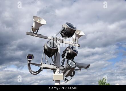 Nahaufnahme von Überwachungskameras, Flutlichtern und Lautsprechern auf der Straßenmast Stockfoto