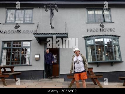 Zwei Männer, die vor den Mason's Arms in High Street, New Mills, Derbyshire rauchten, nachdem Pubs während der Coronavirus-Pandemie geöffnet wurden. Stockfoto