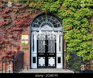 Dublin, Irland - September 09. 2018: Traditionelle Eingangstür im georgischen Stil mit kletternder Efeu-Pflanze an der Wand in Dublin - einer der schönsten h Stockfoto