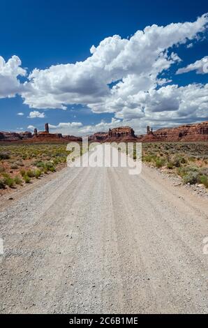 Gerade Feldweg in der Wüste in Richtung rote Felsen Stockfoto