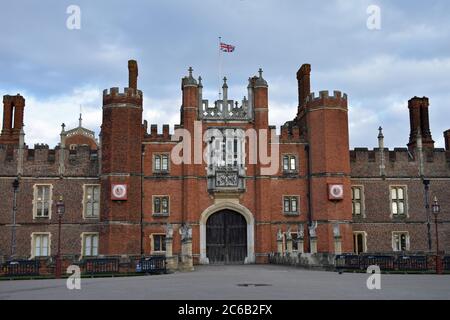 Der Haupteingang zum Hampton Court Palace, London. Die großen Holztüren sind geschlossen und es gibt keine Besucher. TUDOR Mauerwerk und Architektur. Stockfoto