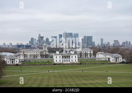 Das Old Royal Navy College und Queens House vom Hügel in Greenwich Park. Das Geschäftsviertel Canary Wharf liegt hinter der Themse. Stockfoto