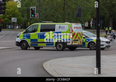 Southend-on-Sea, Großbritannien. Juli 2020. Zwei Fahrzeuge der Essex Police – markierte Van und Auto – stationiert an einer verkehrskontrollierten Kreuzung am Queensway, Southend. Die Szene deutet auf eine aktive Verkehrskontrolle oder Reaktion auf einen Vorfall hin, mit roten Ampeln und städtischer Umgebung. Die Polizei von Essex hat bestätigt, dass ein Mann am Tatort gestorben ist, nachdem er von der Fußgängerbrücke in Queensway gefallen ist. Penelope Barritt/Alamy Live News Stockfoto