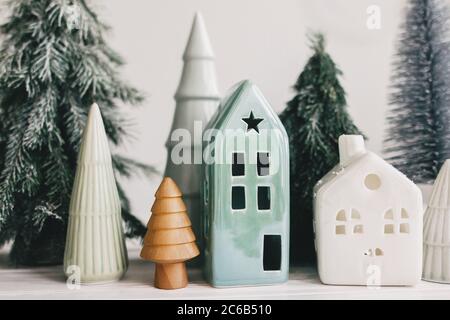 Frohe Feiertage. Miniatur gemütliches Dorf, Keramik Häuser, Holz und handgemachte weihnachtsbäume. Weihnachten kleine Häuser und Bäume auf weißem Hintergrund. Fe Stockfoto