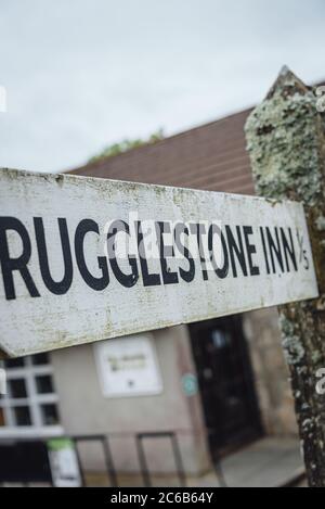 Ein Wegweiser zum Rugglestone Inn (⅕ Meile entfernt) in Widdecombe-in-the-Moor Dorf, Dartmoor Nationalpark, Devon, England, Großbritannien Stockfoto