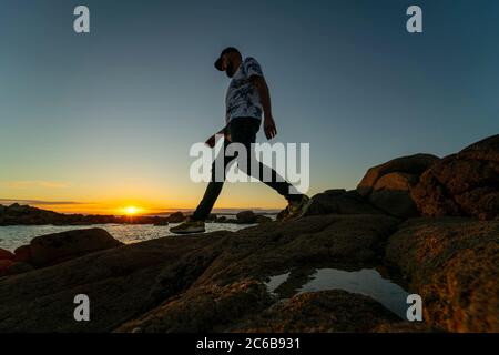 Mann, der am Strand von La Lanzada, Galizien, Spanien, Europa, am Meer entlang geht Stockfoto