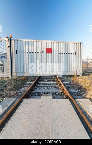 Gleise, die zu einem Industrietor führen Stockfoto