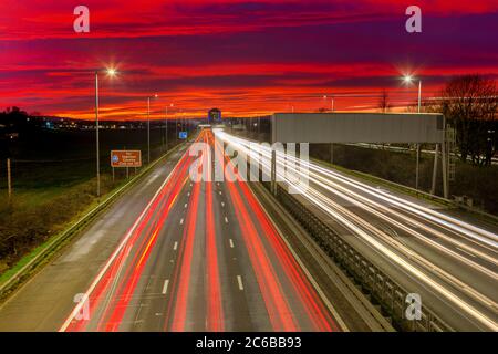 Sonnenuntergang am roten Himmel, Ampelwege, M8 Autobahn, Schottland, Großbritannien, Europa Stockfoto