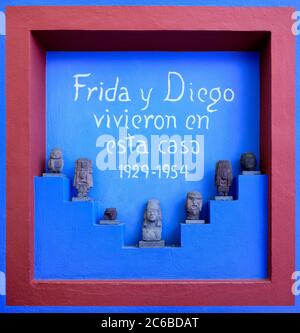 Vorhispanische Skulpturen und Schild mit der Inschrift "Frida und Diego lebten hier" im Frida Kahlo Museum A Stockfoto