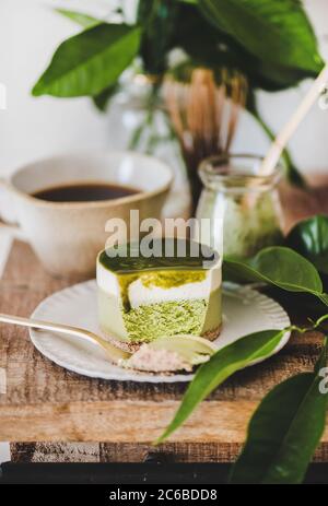 Grüner Matcha Käsekuchen und Kaffee in der Tasse auf der Küchentheke Stockfoto