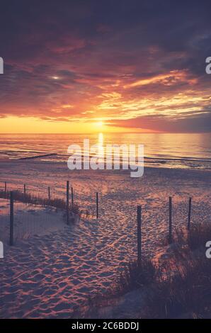 Leerer Strandeingang bei violettem Sonnenuntergang, Farbtonung angewendet. Stockfoto