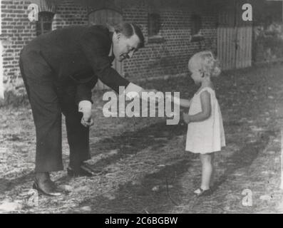 Hitler mit Kind Heinrich Hoffmann fotografiert 1934 Adolf Hitlers offizieller Fotograf und ein Nazi-Politiker und Verleger, der Mitglied des intimen Hitlerkreises war. Stockfoto