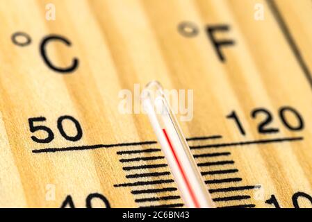 Eine Makroaufnahme eines klassischen Holzthermometers, das eine Temperatur von über 50 Grad Celsius, 122 Grad Fahrenheit zeigt. Stockfoto