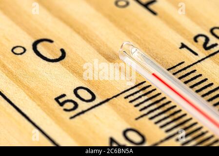 Eine Makroaufnahme eines klassischen Holzthermometers, das eine Temperatur von über 50 Grad Celsius, 122 Grad Fahrenheit zeigt. Stockfoto