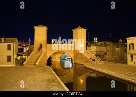 Nachtlandschaft des 1638 Trepponti architektonischen Komplexes, die berühmteste Brücke im Dorf Comacchio in Ferrara, Italien Stockfoto