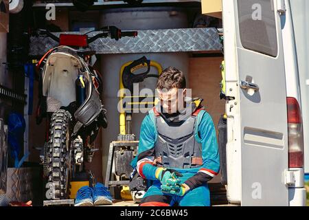 Junger Mann sitzt in Pickup-Truck mit Dirt Bike, Motorrad, Rest zwischen den Rennen Stockfoto