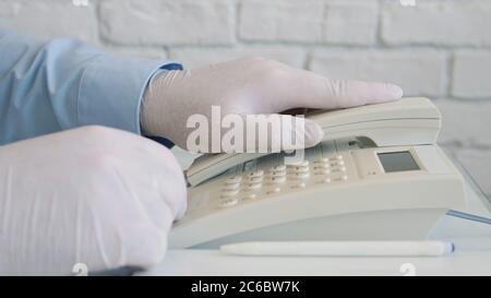 Mann trägt Schutzhandschuhe in den Händen mit Telefonkommunikation, Social Distancing Lifestyle Stockfoto