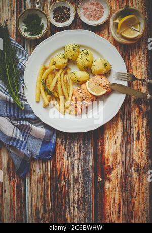 Frischer und schmackhafter gebackener Lachs mit jungen gekochten Kartoffeln und gelben Bohnen. Stockfoto