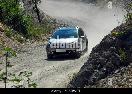 Allradantrieb auf einer schmalen Schotterstraße. SUV fährt auf einer schmalen unbefestigten Straße. Stockfoto