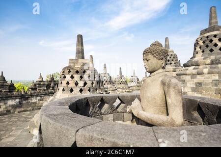 (Selektive Fokus) einen atemberaubenden Blick auf einen Buddha Statue im Vordergrund und einige glockenförmigen Stupas im Hintergrund. Stockfoto