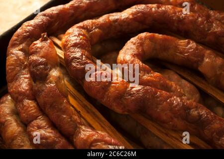 Im Ofen gebackene, braune, hausgemachte Wurst, fotografiert, während sie noch heiß auf einer Dose aus nächster Nähe ist Stockfoto