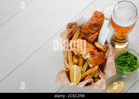 Bier zu Fisch und Pommes. Zugabe von pürierten grünen Erbsen und Zitrone Stockfoto