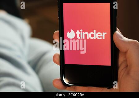 Tinder-Logo auf dem Smartphone-Bildschirm in mans Hand, man mit Zunder-Anwendung für Dating und auf der Suche nach Liebe, Juli 2020, Prag, Tschechische Republik. Stockfoto
