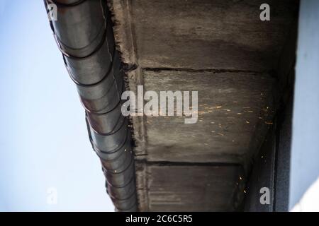 Ersatz-Rinnensystem mit Schweißmaschine für ein Metalldach. Dachrinnenabflusssystem auf dem Dach. Schneiden Sie eine Dachrinne ab. Stockfoto