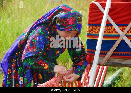 JAMAL, RUSSLAND - 27. AUG 2009: Kleine Völker des russischen Nordens. Yamal-Nenzen Autonomer Bezirk. Chanty Herder Frau geschmückt einen Schlitten in Hirten Stockfoto