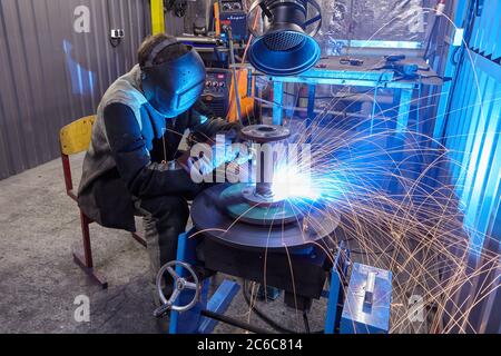 St. Petersburg, Russland - 24. Dezember 2018: Schweißarbeiten an Stahlkonstruktionen Werk, Schweißer schweißt Metallteile. Ein Arbeiter verwendet Arbeitsschutzkleidung, wenn w Stockfoto