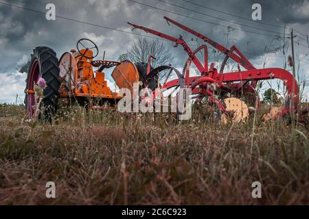 Ein Oldtimer-Traktor und sein Pflug auf einem Trockenland verlassen. Stockfoto