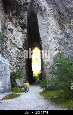 Natürlicher gewölbter Eingang eines ehemaligen Marmorsteinbruchs in den apuanischen alpen des apennins Stockfoto