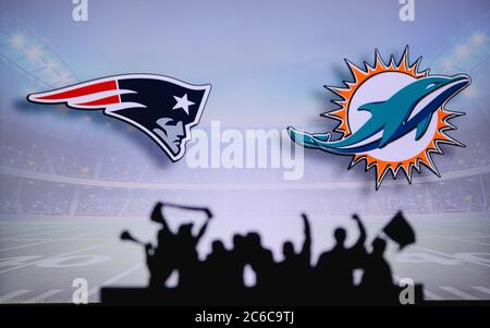 New England Patriots gegen Miami Dolphins. Fans unterstützen NFL Game. Silhouette der Unterstützer, große Leinwand mit zwei Rivalen im Hintergrund. Stockfoto