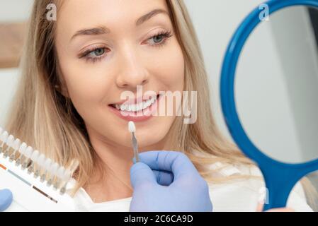 Schöne junge Frau in Stomatologie Klinik. Gesunde Zahnaufhellung. Stockfoto