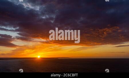 Die Sonnenuntergänge über dem Meer in der Nähe von Thornwick Bay, Flamborough Head, East Yorkshire, Großbritannien Stockfoto