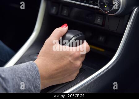 Eine Frauenhand hält einen Automatikschalthebel in der Auto Stockfoto